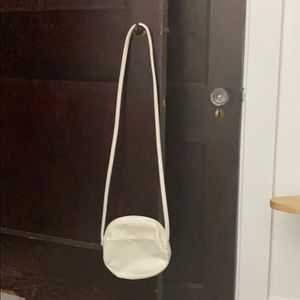 A white circular leather crossbody purse